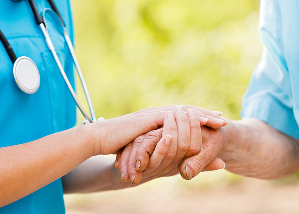 Nurse holding a patients hand