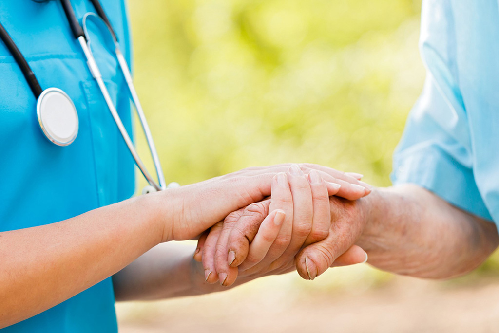 Nurse holding a patients hand